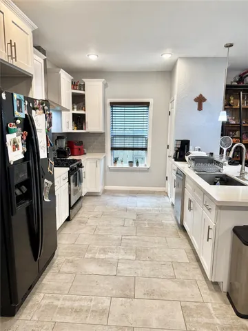 a kitchen with stainless steel appliances granite countertop a stove a sink and a refrigerator