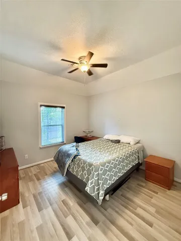 a bedroom with a bed and a ceiling fan