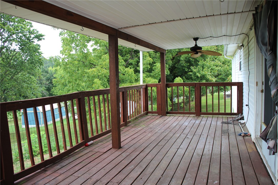 402 Canaan Road Marshall, AR 72650 - Photo 27 of 37 Expansive covered deck featuring wood plank flooring, sturdy wood railings, and a ceiling fan