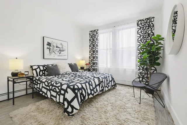 a bedroom with a large bed and a potted plant