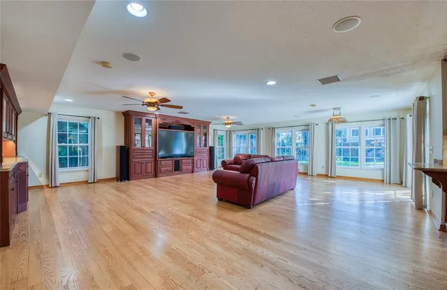 a large kitchen with stainless steel appliances wooden floors and wooden cabinets