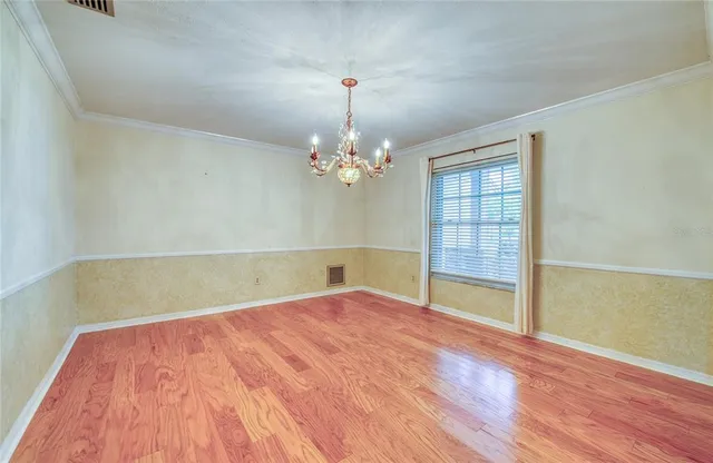 an empty room with windows and ceiling fan