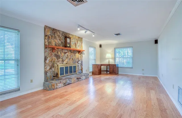 a spacious bedroom with a bed and wooden floor