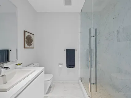 a bathroom with a sink a toilet and shower