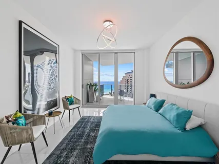 a bedroom with a bed mirror and painting on the wall