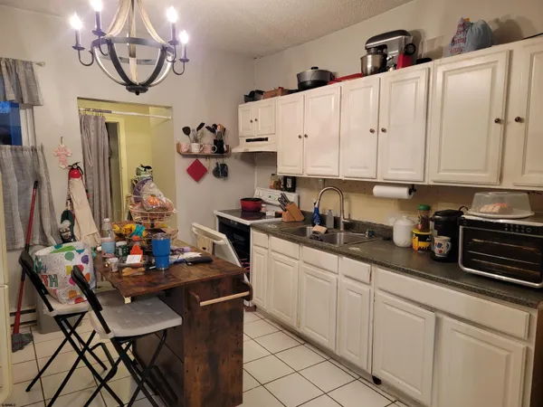 a kitchen with stainless steel appliances granite countertop a sink dishwasher and white cabinets with wooden floor