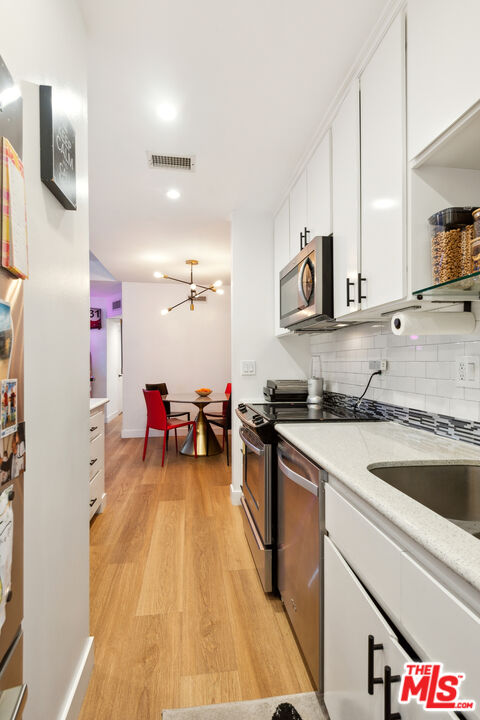 7250 Franklin Avenue, Unit 512 Los Angeles, CA 90046 - Photo 13 of 28 a kitchen that has a lot of cabinets in it and wooden floors