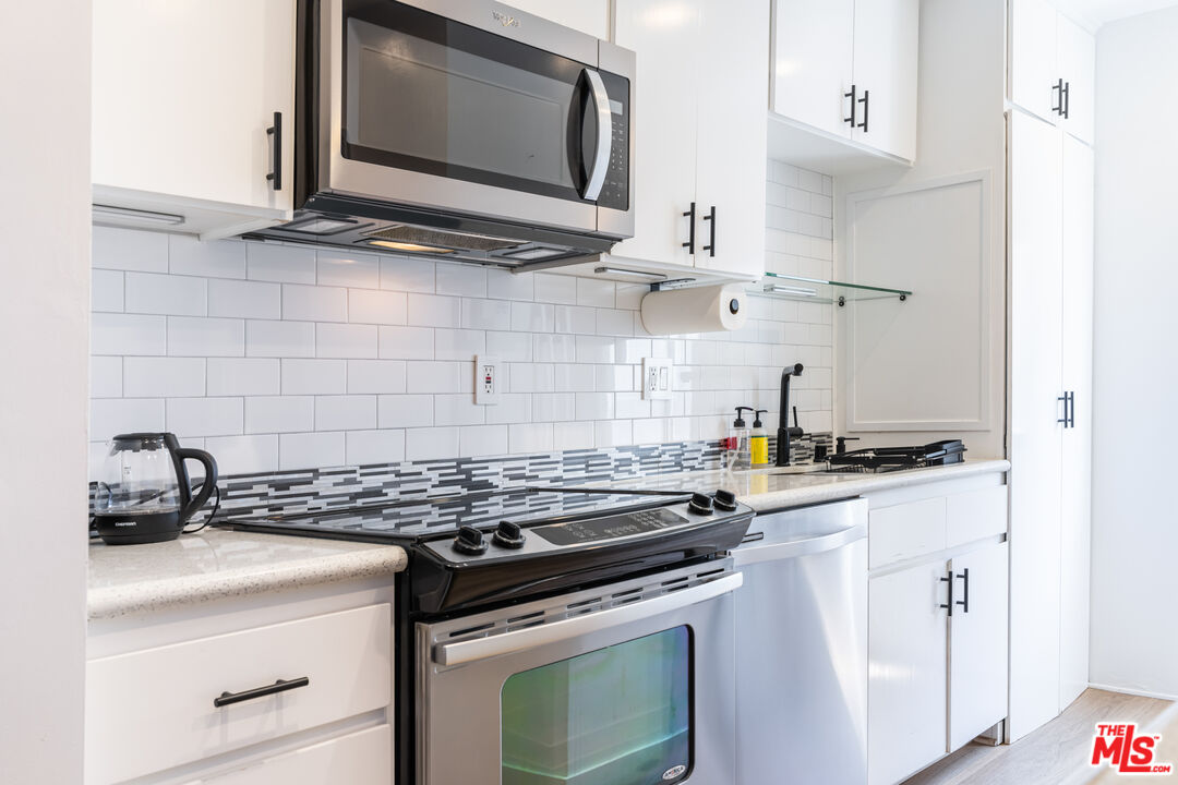 7250 Franklin Avenue, Unit 512 Los Angeles, CA 90046 - Photo 14 of 28 a kitchen with stainless steel appliances granite countertop a stove and a microwave