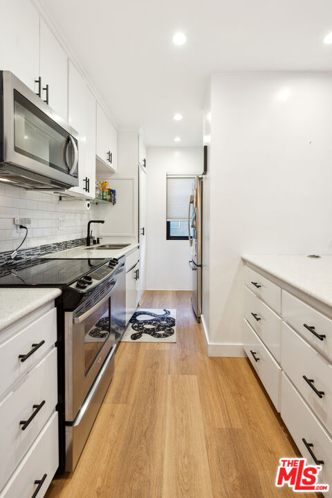 7250 Franklin Avenue, Unit 512 Los Angeles, CA 90046 - Photo 15 of 28 a kitchen with stainless steel appliances a stove a sink and a refrigerator