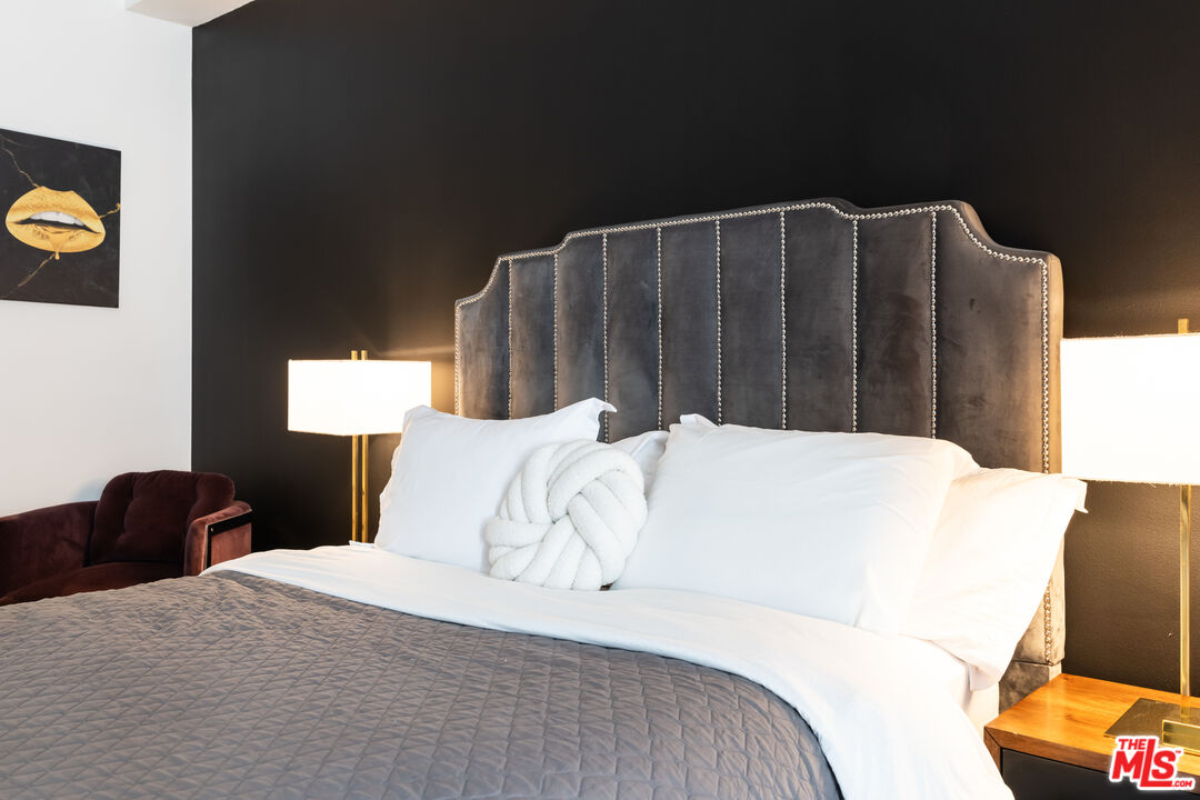 7250 Franklin Avenue, Unit 512 Los Angeles, CA 90046 - Photo 19 of 28 a bed sitting in a bedroom next to a window with wooden floor