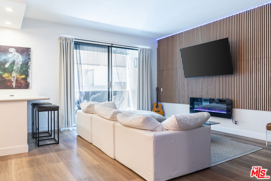 7250 Franklin Avenue, Unit 512 Los Angeles, CA 90046 - Photo 9 of 28 a living room with furniture a flat screen tv and a floor to ceiling window
