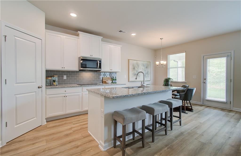 477 Collier Mls Road Lawrenceville, GA 30045 - Photo 17 of 40 a kitchen with granite countertop a dining table chairs and granite counter tops