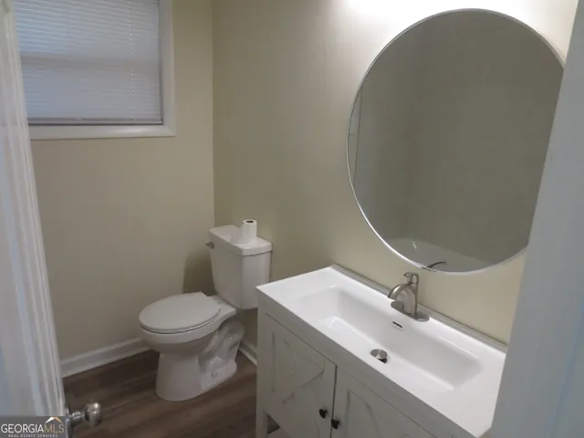 a bathroom with a sink toilet and a mirror