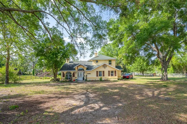 a front view of a house with a yard and trees