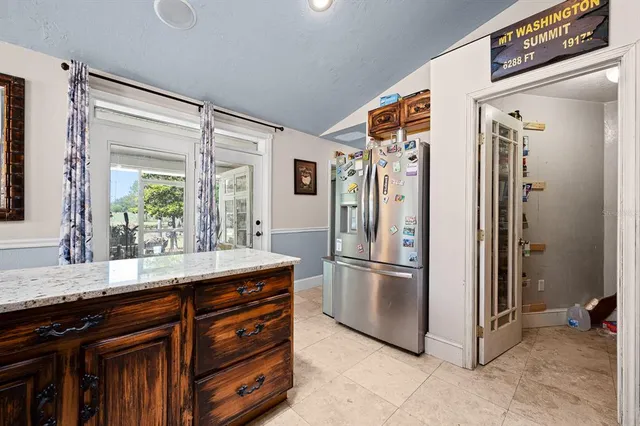 a kitchen with stainless steel appliances granite countertop a refrigerator and a sink