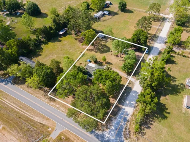 an aerial view of house with a yard and swimming pool