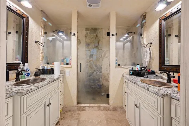a bathroom with a double vanity sink mirror and shower