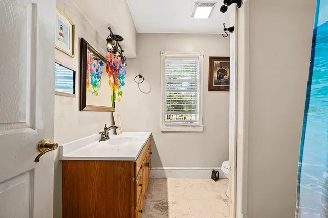 a bathroom with a sink a mirror and painting on the wall