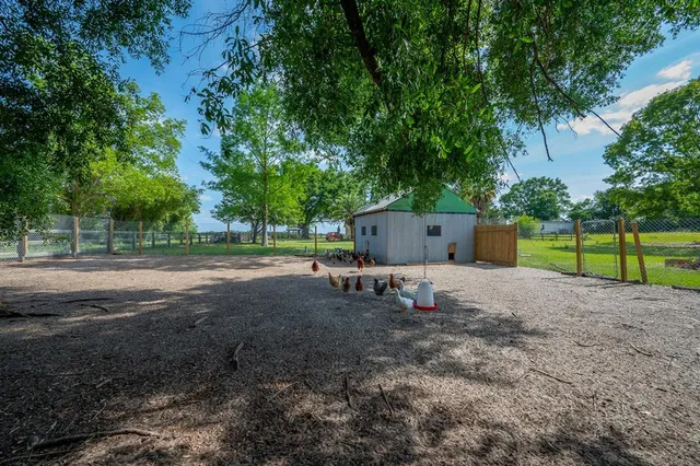 a backyard of a house with table and chairs plants and trees
