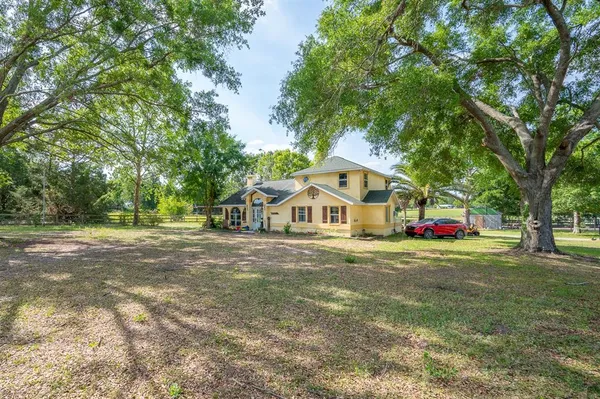 a front view of a house with a yard and trees