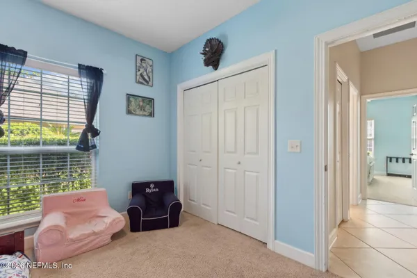 a spacious bedroom with a bed and a chandelier