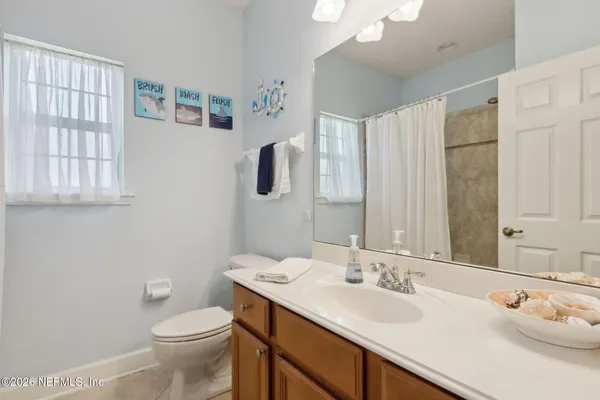 a bathroom with a sink a toilet and a shower curtain