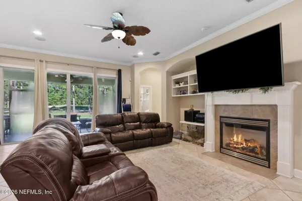 a living room with furniture a flat screen tv and a fireplace