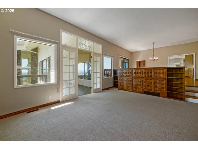 a view of an empty room with a fireplace and windows
