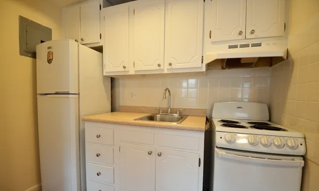 a kitchen with stainless steel appliances a stove a refrigerator and cabinets