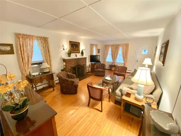 a living room with furniture fireplace and a large window
