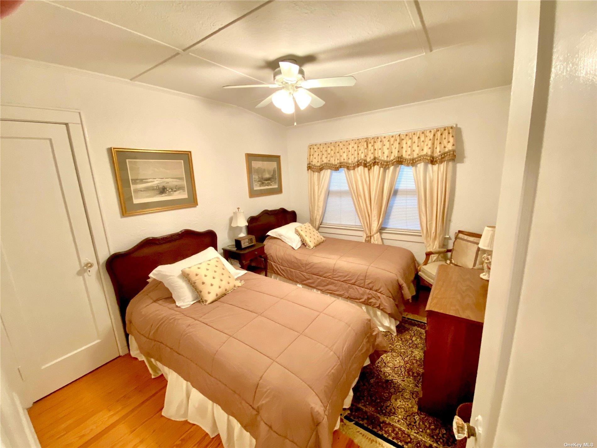 111 Inwood Avenue Point Lookout, NY 11569 - Photo 8 of 11 a bedroom with a bed and a chandelier