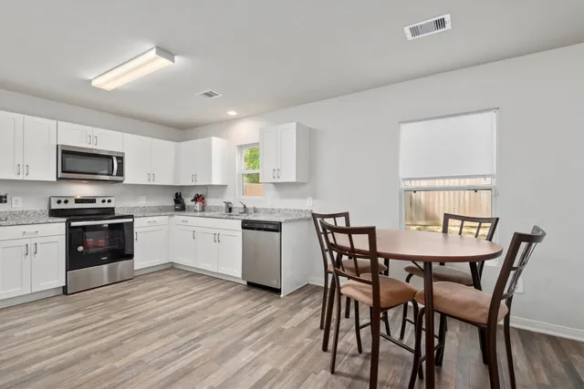 a kitchen with stainless steel appliances kitchen island granite countertop a kitchen island hardwood floor sink and stove