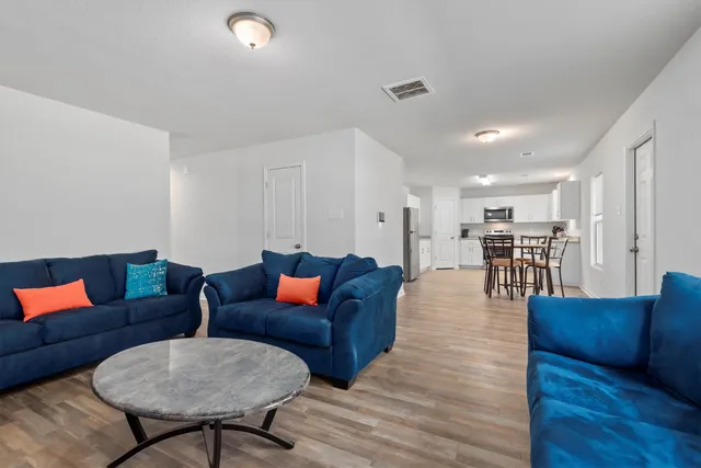 a living room with furniture and wooden floor
