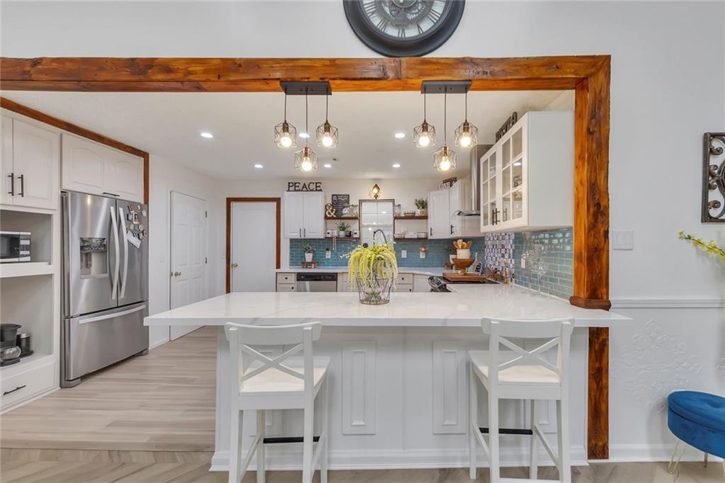 52 Glenda Drive Southwest Rome, GA 30165 - Photo 16 of 50 a kitchen with stainless steel appliances granite countertop a table chairs in it and wooden floors