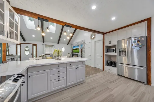 a kitchen with white cabinets and stainless steel appliances