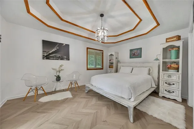 a spacious bedroom with a bed and a chandelier