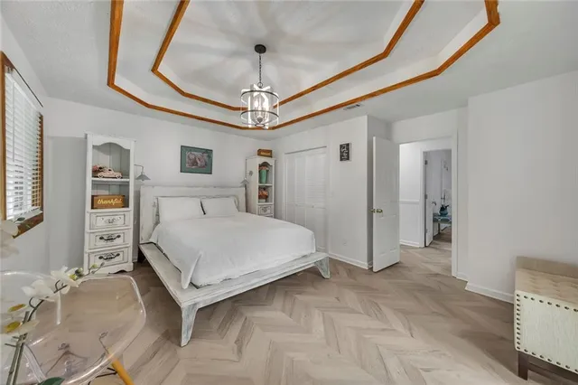 a bedroom with a large bed and a chandelier