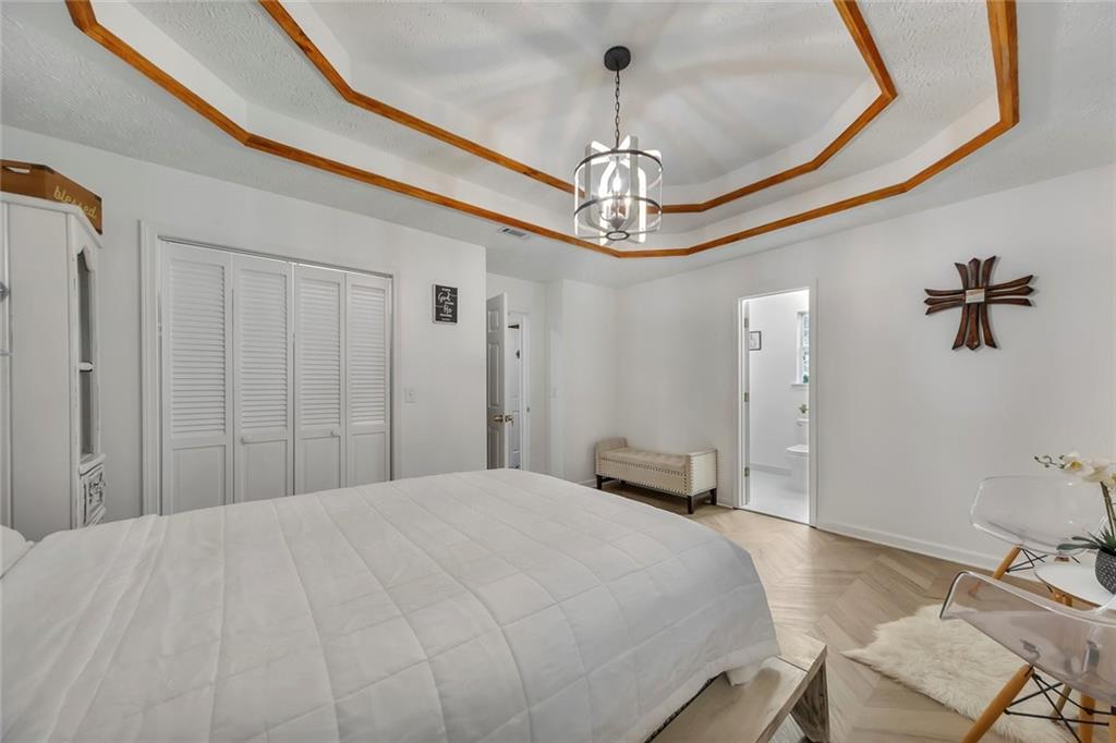 52 Glenda Drive Southwest Rome, GA 30165 - Photo 27 of 50 a bedroom with a large bed and a chandelier