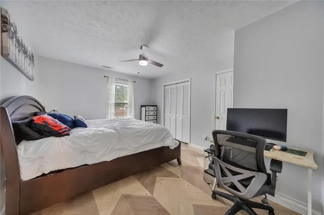 a bedroom with a bed and a ceiling fan
