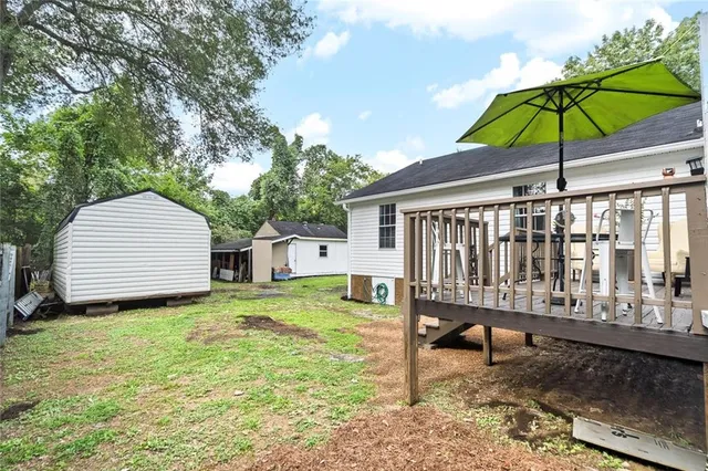 a view of a deck with furniture and a barbeque grill with wooden floor and fence