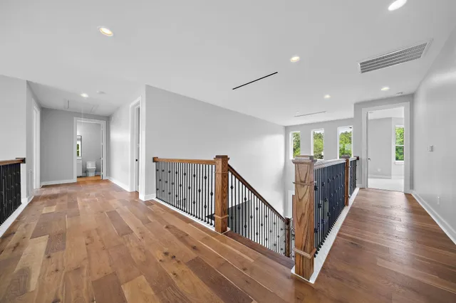 a view of a hallway with wooden floor and stairs