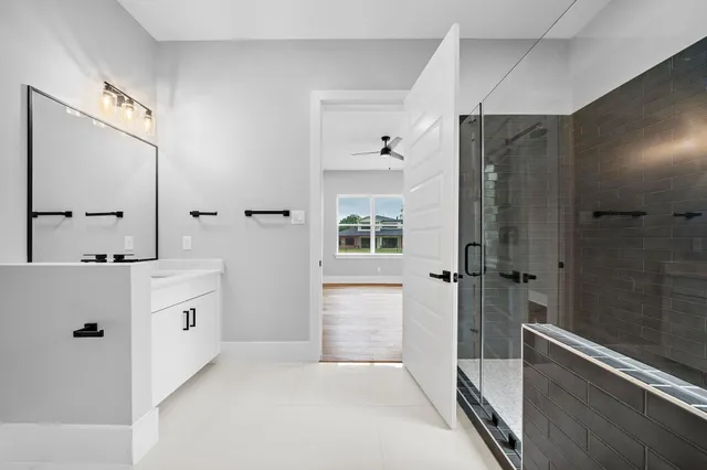 a bathroom with a double vanity sink a mirror and a bathtub