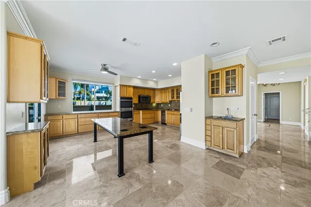 a kitchen with stainless steel appliances granite countertop a refrigerator and a stove top oven