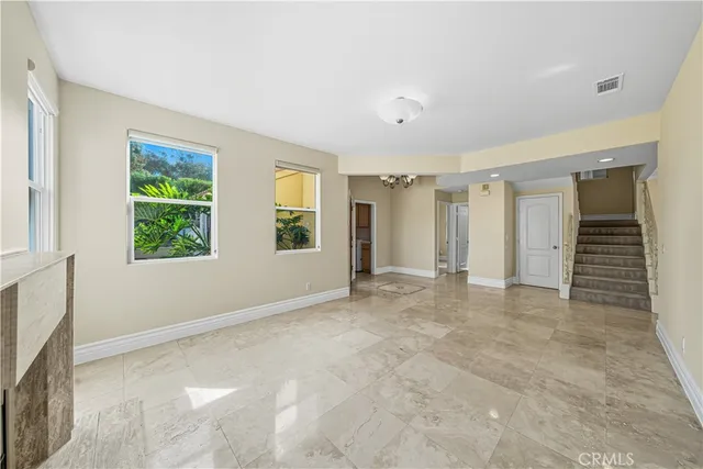 an empty room with windows and ceiling fan