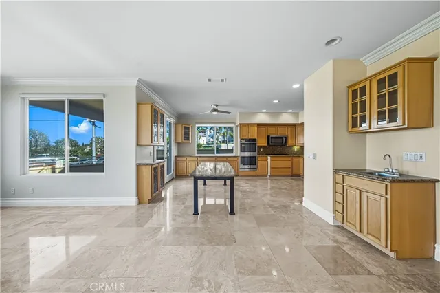 a large kitchen with kitchen island a sink a stove a refrigerator cabinets and a dining table