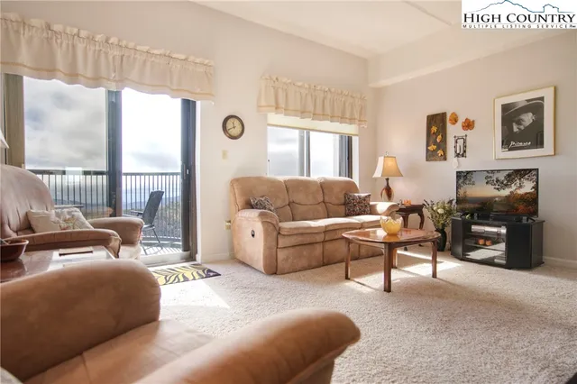 a living room with furniture large window and a fireplace