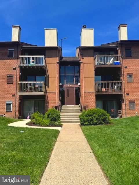 106 Mountain Road, Unit 2C Pasadena, MD 21122 - Photo 1 of 17 a front view of multi story residential apartment building with yard