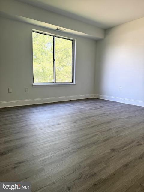 106 Mountain Road, Unit 2C Pasadena, MD 21122 - Photo 12 of 17 an empty room with wooden floor and windows