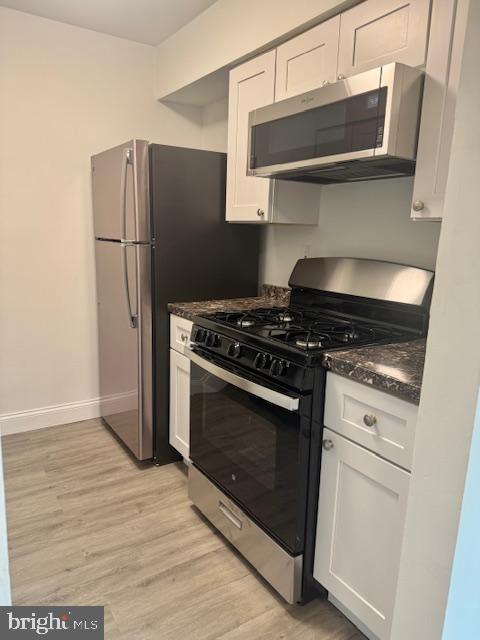 106 Mountain Road, Unit 2C Pasadena, MD 21122 - Photo 9 of 17 a kitchen with stainless steel appliances white cabinets and wooden floor