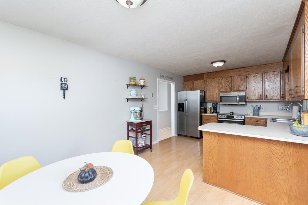 138 Buckboard Road Waynesboro, VA 22980 - Photo 16 of 54 a kitchen with stainless steel appliances a refrigerator a sink a stove a dining table and chairs